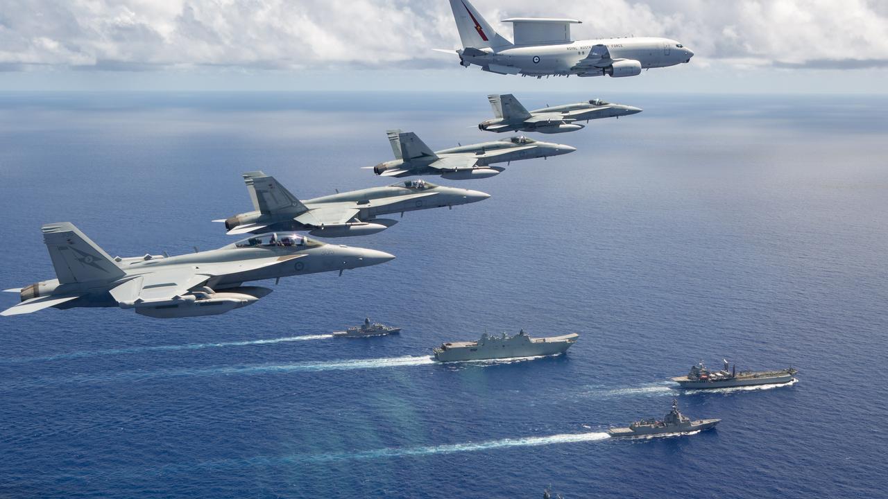 A formation from the Royal Australian Air Force fly over a Royal Australian Navy task group of HMA Ships Canberra, Hobart, Stuart, Arunta and Sirius in July 2020.