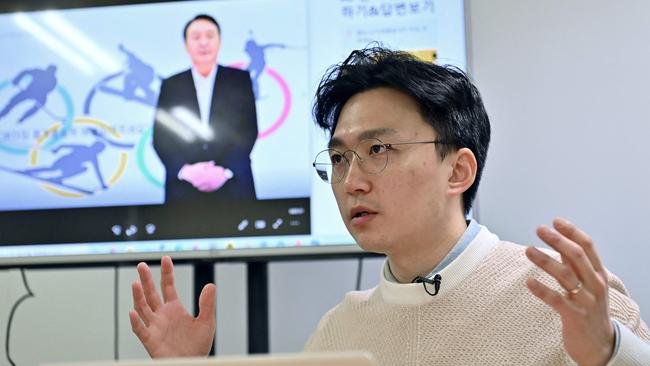 Baik Kyeong-hoon, director of the ‘AI Yoon’ team, with the avatar on the screen behind. Picture: AFP