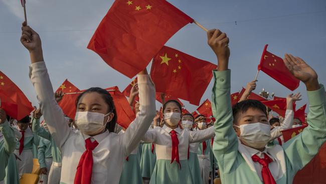 Chinese students wave party and national flags at a ceremony marking the 100th anniversary of the Communist Party at Tiananmen Square on July 1. Picture: Getty