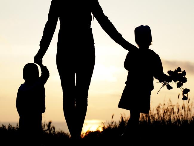 mother with her children at the seaside at sunset