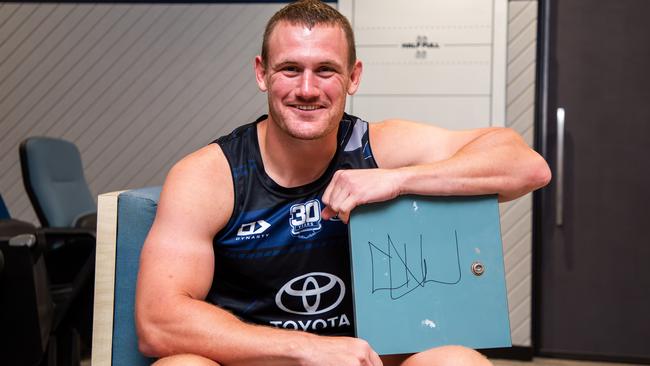 Cowboys player Coen Hess with his signed locker door which will go up for auction as part of the Cowboys Community Foundation's Christmas Auction.