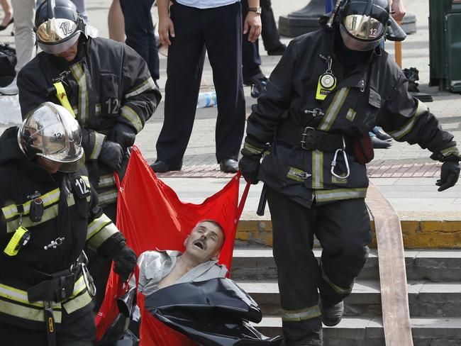 Rescuers carry an injured passenger injured. Picture: Mikhail Japaridze