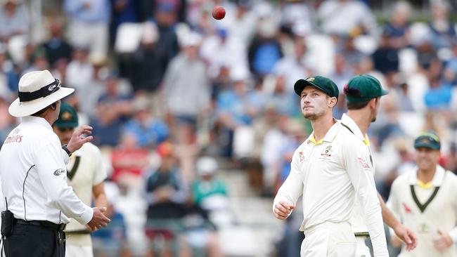 Australia’s Cameron Bancroft (R) throws the ball to Umpire Richard Illingworth (L).