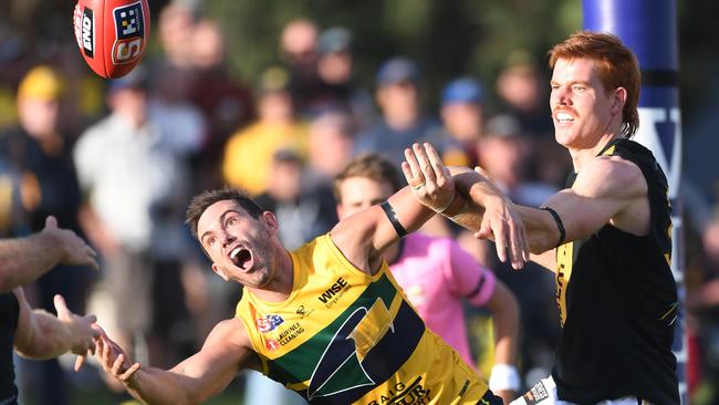 Eagle Daniel Menzel brushes off the attention of opponent Toby Pink to dive for a mark in Monday’s Anzac Day grand final rematch at Woodville Oval. Picture: Tricia Watkinson.