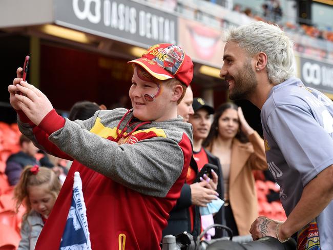 Izak Rankine of the Suns poses for photographs with fans prior to the start of the round 22 AFL match between the Gold Coast Suns and the Geelong Cats at Metricon Stadium. Picture: Matt Roberts/Getty Images