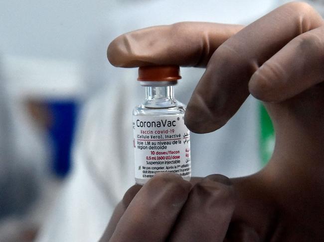 A lab technician from the Algerian pharmaceutical company Saidal, shows a vial of the locally-produced Chinese-developed Sinovac (CoronaVac) Covid-19 vaccine, in the northeastern Algerian city of Constantine, on September 29, 2021. (Photo by RYAD KRAMDI / AFP)