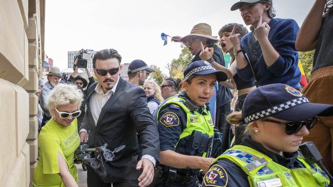 British activist Kellie-Jay Keen, left, leaves the Tasmanian parliament grounds as Equality Tasmania and LGBTQI+ supporters counter-protest on Tuesday. Picture: Chris Kidd