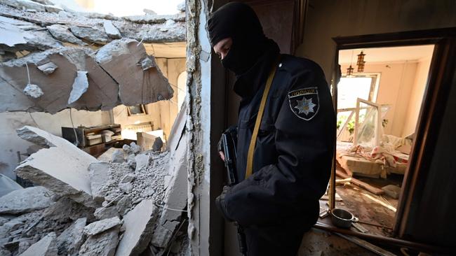 A police officer stands inside a destroyed apartment in housing block hit by debris from a downed rocket in Kyiv. Picture: AFP