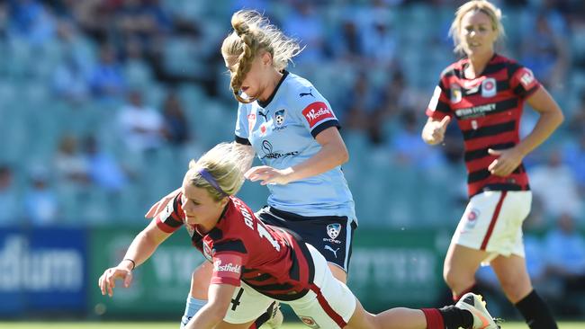 Alexis Arlitt (left) of the Wanderers competes for the ball with Remy Siemsen (centre) of Sydney FC.