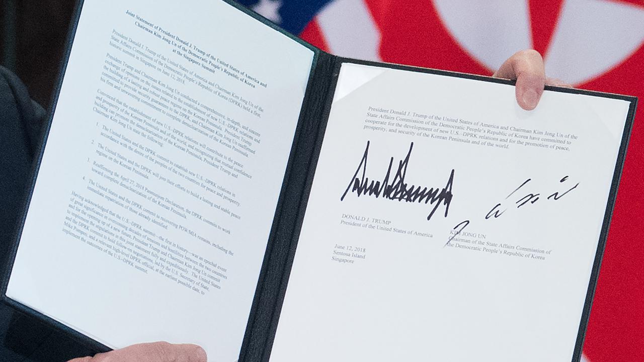 Mr Trump holds up a document signed by him and North Korea’s leader Kim Jong-un following a signing ceremony during their historic US-North Korea summit.