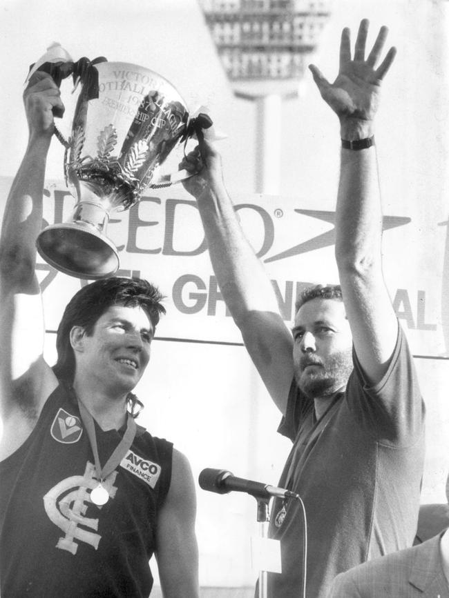 Robert Walls holds the premiership cup aloft with former Carlton captain Stephen Kernahan.