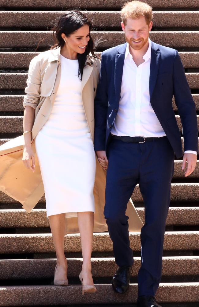 Meghan Markle in Sydney, wearing a basic dress by Karen Gee ($1800) and a $2555 trench by Brandon Maxwell, pictured with Mike Ross. Oh, that’s actually Prince Harry. Picture: Matrix