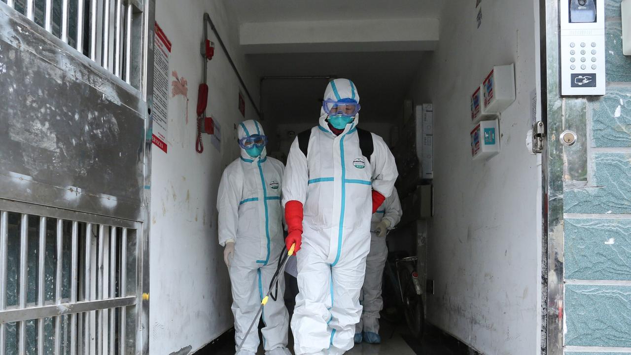 Medical staff wearing protective clothing disinfect a residential area in Ruichang, part of Jiujiang in China’s central Jiangxi province next to Hubei province. Picture: STR/AFP