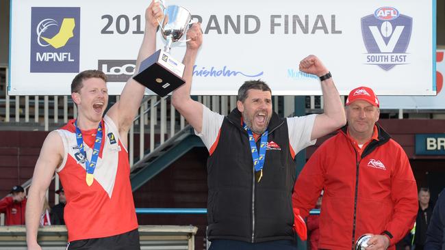 Jamie Mollo (middle) and captain Marcus Dal Lago lift with the 2019 Division 2 premiership cup. Picture: Chris Eastman/AAP