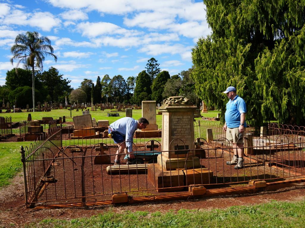 Michael Wagner and Ben Dawson working to restore the gravestones in Drayton Cemetery that were vandalised last year, as part of the Headstone Healing Project.