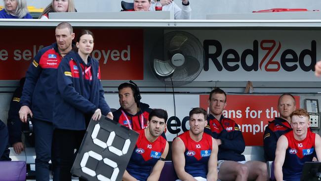 HOBART, AUSTRALIA – AUGUST 6: Harrison Petty of the Demons is seen at the back of the bench after being subbed out of the game during the 2023 AFL Round 21 match between the North Melbourne Kangaroos and the Melbourne Demons at Blundstone Arena on August 6, 2023 in Hobart, Australia. (Photo by Dylan Burns/AFL Photos via Getty Images)