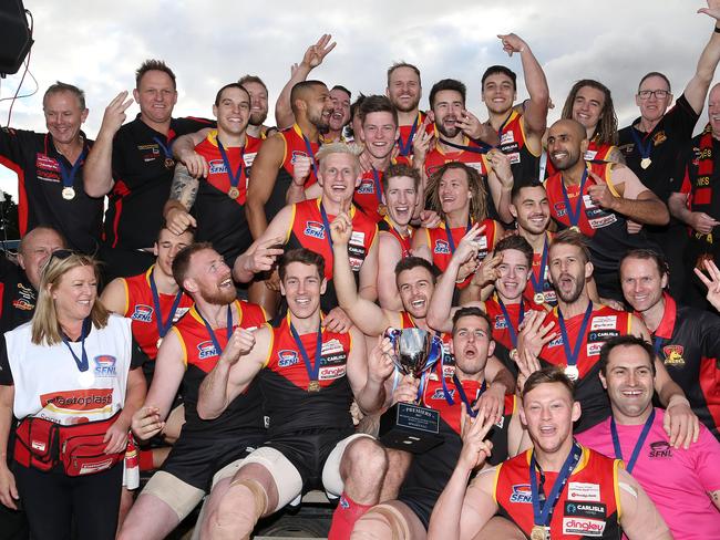 Three in a row: the Dingoes celebrate a hat-trick of premierships.