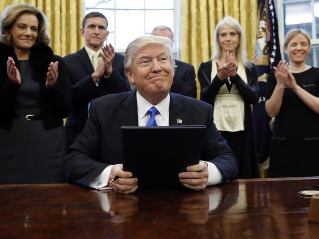 President Donald Trump smiles after signing three executive actions in the Oval Office. Picture: AP
