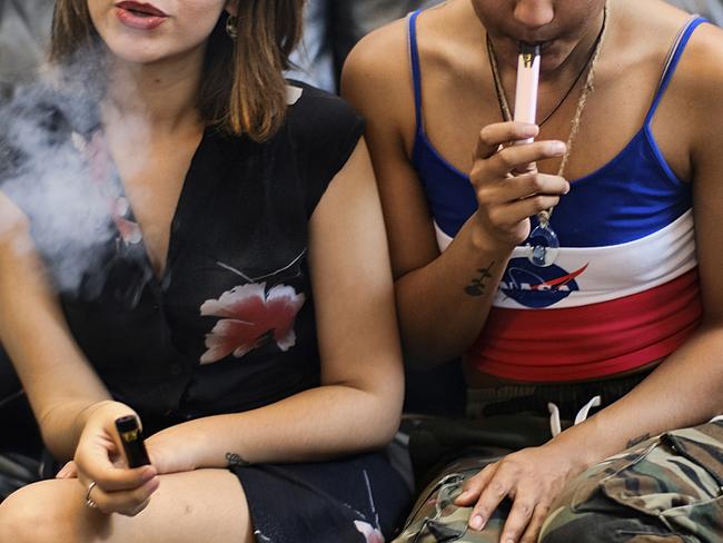 Two women smoke cannabis vape pens at a party in Los Angeles. Picture: Richard Vogel/AP Photo