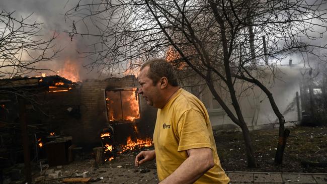 Yevghen Zbormyrsky, 49, runs in front of his burning house after being shelled in the city of Irpin, outside Kyiv. Picture: AFP