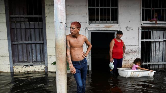 Locals stand outside their homes in a flooded area of Batabano, Mayabeque Province, Cuba, on September 26, 2024, after the passage of Hurricane Helene. Picture: AFP