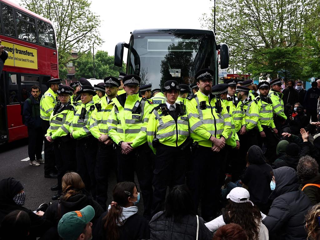 Metropolitan Police officers surround a bus in Peckham, south London, as protesters attempt to block the removal of migrants to the Bibby Stockholm barge in Dorset. This follows the UK government’s plan to detain people before commencing controversial deportation flights to Rwanda. Picture: Henry Nicholls/AFP