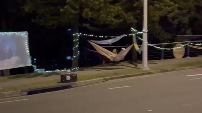 The Hammock Man rigged up a big screen on the street below to watch a movie with the pair