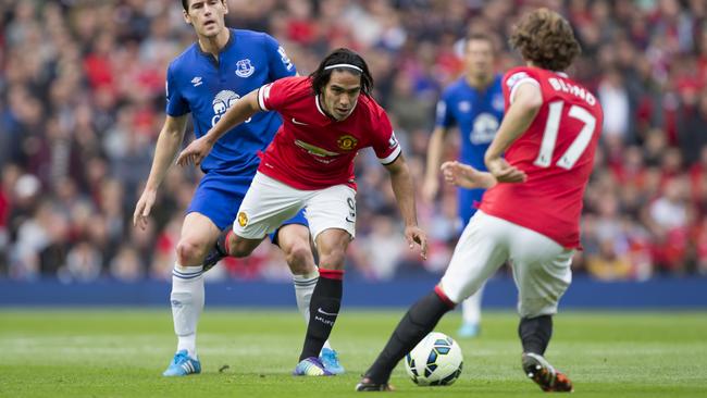 Manchester United's Radamel Falcao passes the ball to teammate Daley Blind as Everton's Gareth Barry, left, looks