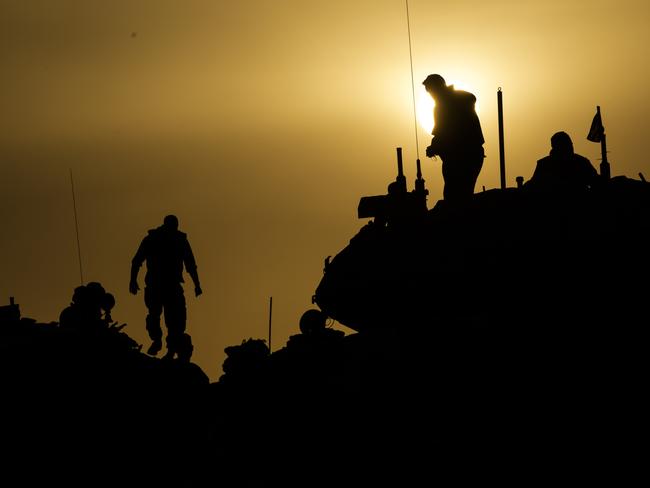 Israeli soldiers stand on tanks and armored vehicles near the border with the Gaza Strip. Picture: Getty