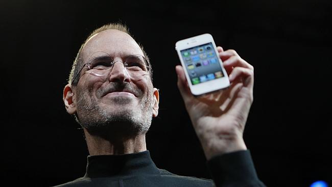 Late Apple founder Steve Jobs with an earlier model of the iPhone.