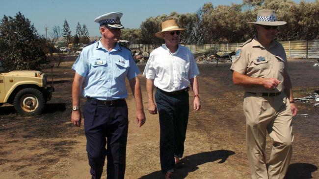 Malcolm Hyde (left) inspects a burnt out caravan park while SA Police Commissioner in 2005. Picture: File