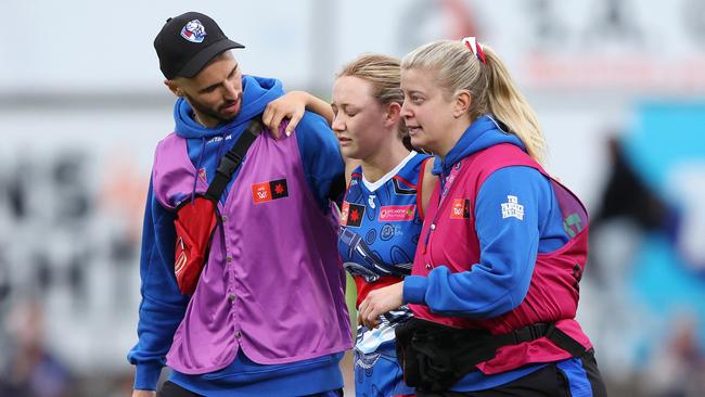 Keely Coyne is helped off the ground after hurting her knee three minutes into the match. Picture: Sarah Reed/AFL Photos via Getty Images