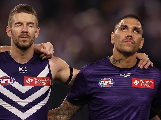 PERTH, AUSTRALIA - MAY 10: Sam Switkoswki, Michael Walters and Michael Frederick of the Dockers line up as the teams pay their respects to former player Cameron McCarthy during the round nine AFL match between Fremantle Dockers and Sydney Swans at Optus Stadium, on May 10, 2024, in Perth, Australia. (Photo by Paul Kane/Getty Images)