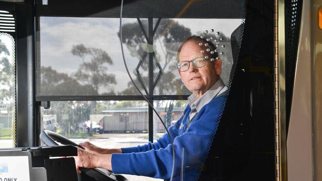 Bus driver Mark Scrymgour, who works for Busways, behind a security screen on a bus. Picture: Brenton Edwards