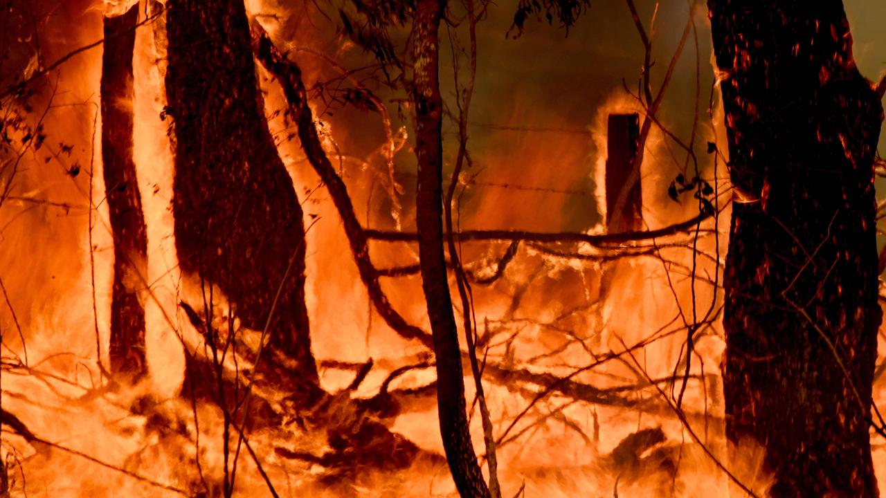 A bushfire burns outside a property near Taree. Picture: AFP