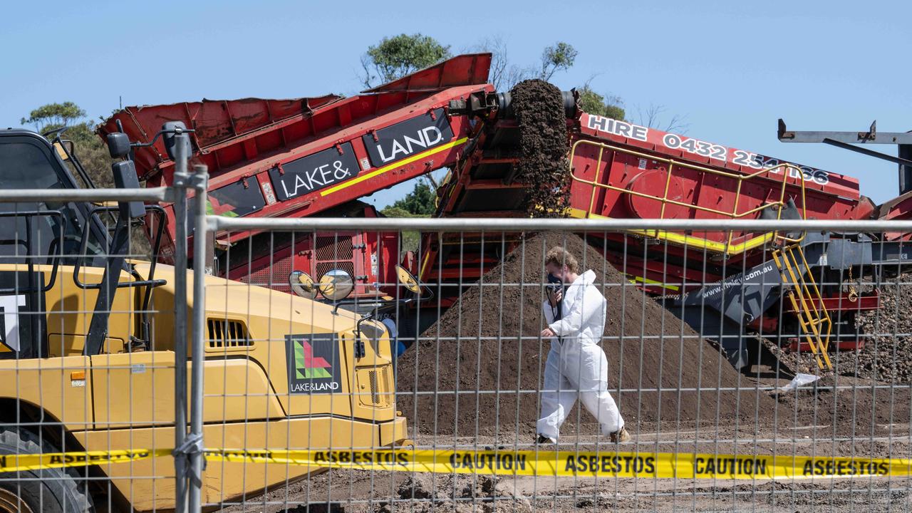 Workers in protective equipment move contaminated soil with asbestos signs around the building site in Murray Road, Queenscliff in March. Picture: Brad Fleet