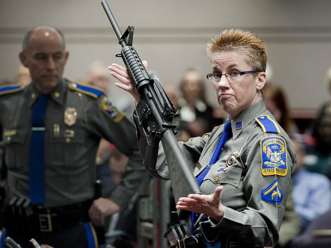 Firearms training unit Detective Barbara J. Mattson, of the Connecticut State Police, holds up a Bushmaster AR-15 rifle in 2013 — the same make and model of gun used by Adam Lanza in the Sandy Hook school shooting, during a hearing of a legislative subcommittee in Hartford. Picture: AP Photo/Jessica Hill, File