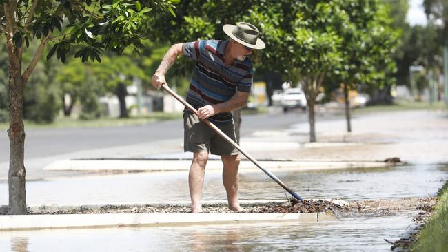 Ballina man Don Johnson clears debris from a drain so floodwater can flow away on Martin Street, next to Ballina Coast High School, on Wednesday. Picture: Liana Boss