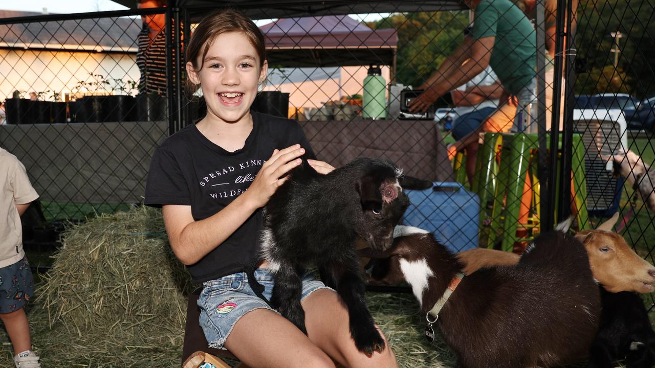 Emily Baxter pats JoJo the baby goat at the Barron River Food Festival, held at the Stratford Dolphins Football Club. Picture: Brendan Radke