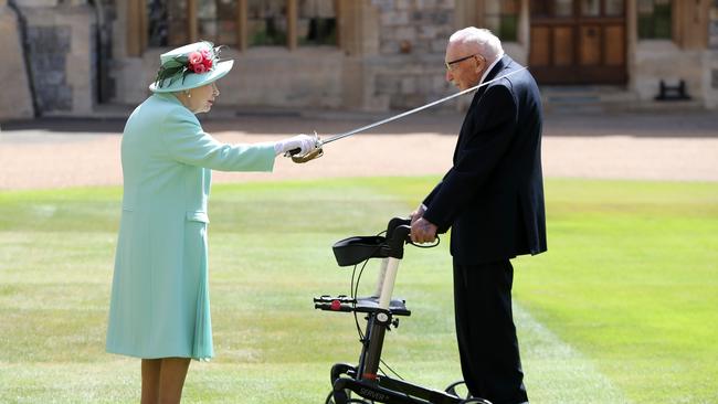 The Queen knights Sir Tom at Windsor Castle. Picture: Getty Images