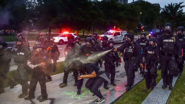 Police officers spray protesters in Denver, Colorado. The city of Denver enacted a curfew for Saturday and Sunday nights. Picture: AFP