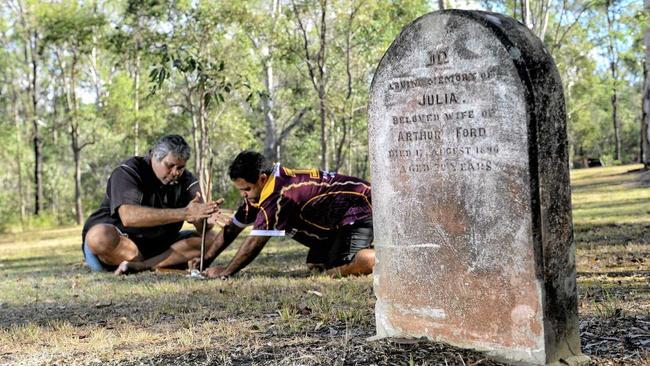 Henry Thompson Jr and Wade Thompson perform a traditional smoke ceremony at the old Deebing Creek Mission Cemetery. Picture: Rob Williams