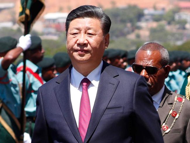 China's President Xi Jinping and Papua New Guinea's Governor-General Bob Dadae (partially obscured) inspect honour guards during a welcome ceremony for a state visit at Parliament House in Port Moresby on November 16, 2018, ahead of Asia-Pacific Economic Cooperation (APEC) Summit. (Photo by DAVID GRAY / POOL / AFP)