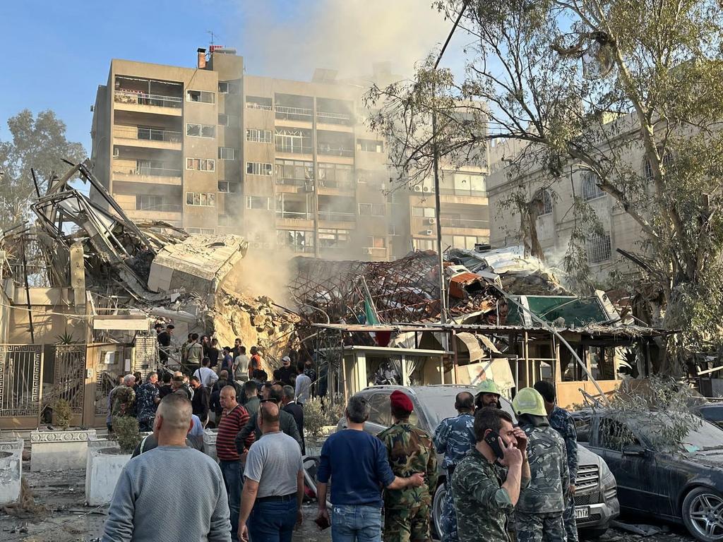 Emergency and security personnel gather at the site of strikes which hit a building adjacent to the Iranian embassy in Syria's capital Damascus, on April 1, 2024.