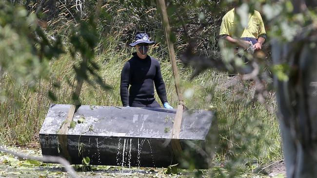 Police retrieve the toolbox from a dam near Srubby Creek at Logan.