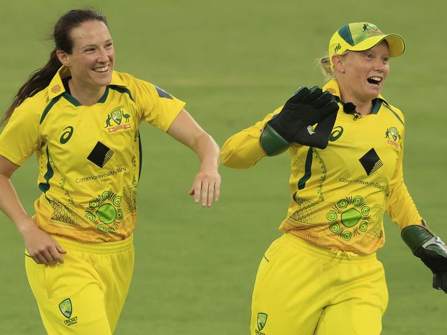 CANBERRA, AUSTRALIA - FEBRUARY 03: Megan Schutt of Australia celebrates the dismissal of Lauren Winfield-Hill of England with Alyssa Healey (R) during game one of the Women's Ashes One Day International series between Australia and England at Manuka Oval on February 03, 2022 in Canberra, Australia. (Photo by Mark Evans/Getty Images)