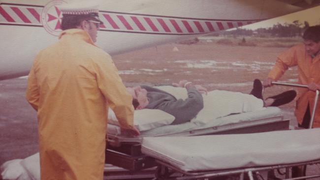 85 year old Ted Woodbry from Southport has cheated death numerous times, and reckons he must have a guardian angel looking after him. Copy pics of the Oxley airlines plane he crashed in at Port Macquarie in 1985, and Ted being taken away on a stretcher. Picture Glenn Hampson