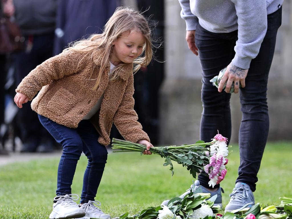 A little girl lays flowers for Prince Philip outside of Windsor Castle. Picture: Getty Images