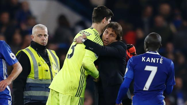 Chelsea's goalkeeper Thibaut Courtois (L) is hugged by Chelsea's Italian head coach Antonio Conte (R).