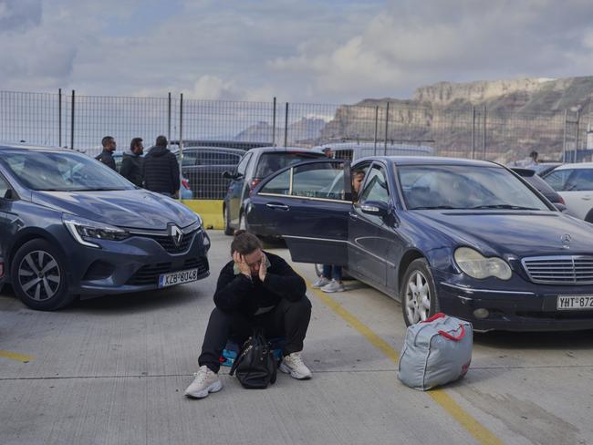 A passenger sits on the dock in Santorini while waiting for a ferry bound for the Greek mainland. Picture: AP